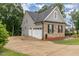 Home exterior featuring 2 car garage and beautiful landscaping around the large driveway at 90 Starwood Dr, Garner, NC 27529