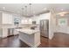 Open kitchen featuring white cabinets, stainless steel appliances and a granite island at 90 Starwood Dr, Garner, NC 27529