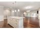 Open-concept kitchen features an island, pendant lighting, and flows into the living area at 90 Starwood Dr, Garner, NC 27529