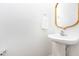 Bright powder room with pedestal sink, wood trimmed mirror, and classic design at 925 Spring Meadow Dr, Durham, NC 27713