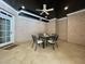 Outdoor dining area on a covered patio with ceiling fan and brick exterior at 1000 Clovelly Ct, Raleigh, NC 27614