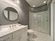 A modern bathroom with a white vanity, tile flooring, and a glass-enclosed shower at 1000 Clovelly Ct, Raleigh, NC 27614