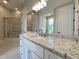 Bathroom featuring a large vanity with granite countertop and white cabinets with a large mirror and vanity lighting at 1000 Clovelly Ct, Raleigh, NC 27614