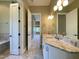 Bathroom featuring dual sinks, white cabinetry, granite countertop, tile floors, plus separate tub and doorway at 1000 Clovelly Ct, Raleigh, NC 27614
