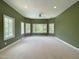 Spacious bedroom with large windows and plush carpeting, providing lots of natural light and beautiful outdoor views at 1000 Clovelly Ct, Raleigh, NC 27614