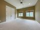 Inviting bedroom with neutral carpeting, a ceiling fan, multiple windows, and a large closet, offering comfort and storage at 1000 Clovelly Ct, Raleigh, NC 27614