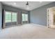 Airy bedroom featuring large windows with curtains, a ceiling fan, and neutral carpeting, creating a serene atmosphere at 1000 Clovelly Ct, Raleigh, NC 27614