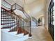 Elegant foyer boasting a curved staircase, rich wood accents, and natural light at 1000 Clovelly Ct, Raleigh, NC 27614