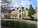 Stately home featuring a columned balcony, brick facade, landscaped yard, and winding driveway at 1000 Clovelly Ct, Raleigh, NC 27614