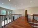 Second floor hallway with hardwood floors and iron railing at 1000 Clovelly Ct, Raleigh, NC 27614