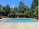 A backyard pool surrounded by mature trees and lounge seating, perfect for relaxation at 1000 Clovelly Ct, Raleigh, NC 27614