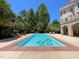 A luxurious pool area complete with lounge chairs and lush landscaping with a brick house in the background at 1000 Clovelly Ct, Raleigh, NC 27614