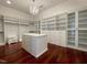 Spacious walk-in closet with custom shelving, drawers, a center island, and a stylish chandelier at 1000 Clovelly Ct, Raleigh, NC 27614
