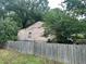 Back exterior with a privacy fence and peeling paint on wooden walls at 1002 Loius St, Burlington, NC 27217