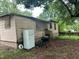 View of backyard with peeling exterior, discarded refrigerator, and old grill at 1002 Loius St, Burlington, NC 27217