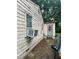 Side of building with weathered, peeling paint and an old air conditioning unit at 1002 Loius St, Burlington, NC 27217