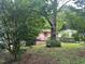 Home exterior with front porch and ramp surrounded by large shady trees at 1002 Loius St, Burlington, NC 27217