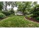 Lush backyard featuring manicured lawn and a detached garage or shed, ideal for storage or hobbies at 1002 Vance St, Raleigh, NC 27608
