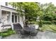 Charming backyard with stone patio, elegant seating, lush greenery, and access to the house at 1002 Vance St, Raleigh, NC 27608