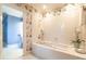 Bathroom showcasing a large tub and shower with floral wallpaper and a view to the vanity at 1002 Vance St, Raleigh, NC 27608