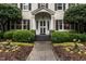 Charming home entrance with a brick walkway, manicured bushes, and decorative front door at 1002 Vance St, Raleigh, NC 27608