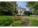 Elegant white brick home featuring lush landscaping, mature trees, and a well-maintained lawn at 1002 Vance St, Raleigh, NC 27608