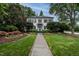 Stately white brick home with a manicured lawn, lush landscaping, and a charming brick walkway at 1002 Vance St, Raleigh, NC 27608