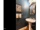 Elegant powder room featuring designer wallpaper, pedestal sink, and ornate mirror at 1002 Vance St, Raleigh, NC 27608