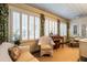Sunroom features a piano, wicker furniture, and windows with white plantation shutters at 1002 Vance St, Raleigh, NC 27608