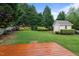 Expansive backyard featuring a shed, lush greenery, and a wooden deck at 1012 Coram Fields Rd, Wake Forest, NC 27587