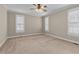 Spacious bedroom with neutral carpet, two windows, and a ceiling fan at 1012 Coram Fields Rd, Wake Forest, NC 27587