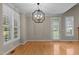 Elegant dining room with hardwood floors, plantation shutters, and modern light fixture at 1012 Coram Fields Rd, Wake Forest, NC 27587