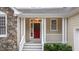 Inviting front entrance with a red door, white railings and beautiful stone accents at 1012 Coram Fields Rd, Wake Forest, NC 27587