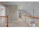 Hallway with wooden railing, carpet, and view to multiple rooms at 1012 Coram Fields Rd, Wake Forest, NC 27587