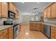 Spacious kitchen with wood cabinets, stainless steel appliances, and hardwood floors at 1012 Coram Fields Rd, Wake Forest, NC 27587