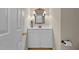 Charming powder room with white vanity, decorative mirror, and fixtures at 1012 Coram Fields Rd, Wake Forest, NC 27587