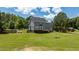 Expansive backyard view featuring a wooden deck, lush green lawn, and a charming fire pit area at 102 Ridge Ln, Youngsville, NC 27596
