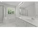 Bright bathroom featuring double vanity, soaking tub, and glass-enclosed shower at 102 Ridge Ln, Youngsville, NC 27596