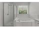 White bathroom featuring a soaking tub and a glass shower enclosure at 102 Ridge Ln, Youngsville, NC 27596