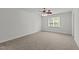Neutral bedroom with a ceiling fan, soft carpet, and natural light from a large window at 102 Ridge Ln, Youngsville, NC 27596