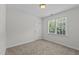 Neutral bedroom featuring neutral carpet, a window and a door at 102 Ridge Ln, Youngsville, NC 27596