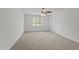 Empty bedroom with a ceiling fan, soft carpet, and natural light from a large window at 102 Ridge Ln, Youngsville, NC 27596