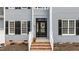Inviting front entrance featuring a black door, wreath, and manicured landscaping at 102 Ridge Ln, Youngsville, NC 27596