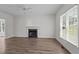 Bright living room with hardwood floors, fireplace, and a ceiling fan at 102 Ridge Ln, Youngsville, NC 27596