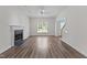 Spacious living room features beautiful wood floors, fireplace and staircase, illuminated by natural light through a window at 102 Ridge Ln, Youngsville, NC 27596
