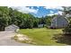 Scenic property view showcasing the home, garage, and lush green landscape with mature trees at 102 Ridge Ln, Youngsville, NC 27596