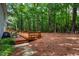 Relaxing backyard featuring a wooden deck, stone pathway, outdoor seating, and a wooded area with a small pergola at 103 Red Cedar Pl, Chapel Hill, NC 27514