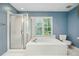 Bathroom with a soaking tub under the window with blinds and an enclosed shower adjacent at 103 Red Cedar Pl, Chapel Hill, NC 27514