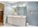 Bathroom with a large vanity with a double sink, mirror, lights, and blue walls at 103 Red Cedar Pl, Chapel Hill, NC 27514