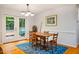 Dining room with hardwood floors, and french doors leading to outside deck surrounded by mature trees at 103 Red Cedar Pl, Chapel Hill, NC 27514